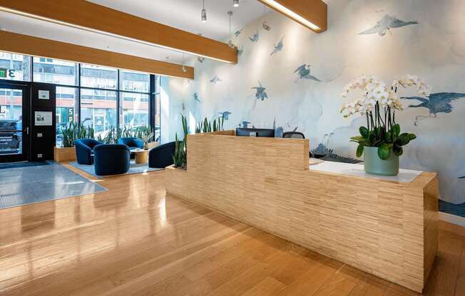 A reception area with a wooden desk and a vase of flowers.