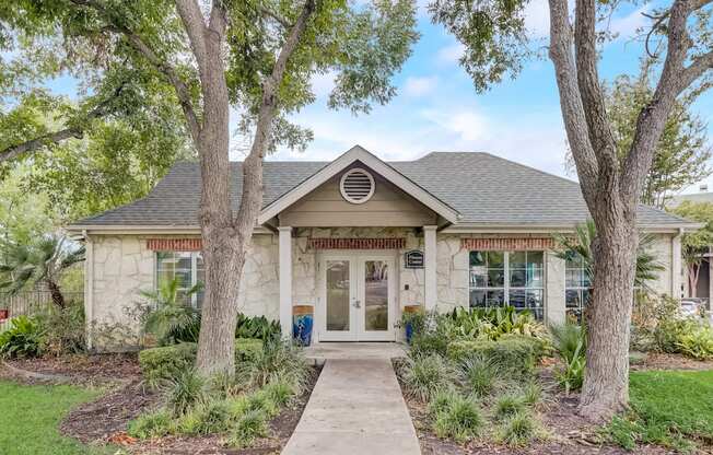 a white house with trees and a sidewalk in front of it