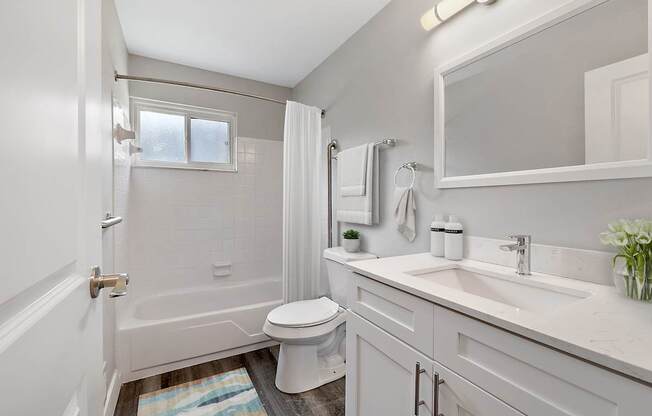 A white bathroom with a toilet, sink, and tub.