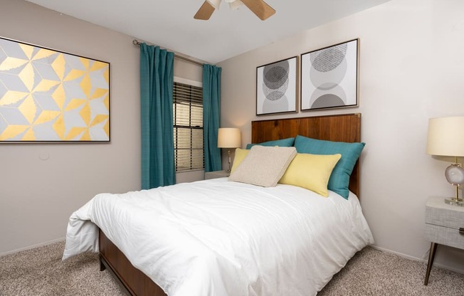 A bedroom with a large bed and a ceiling fan.