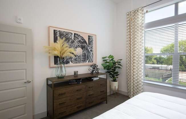 a bedroom with a bed and a dresser and a window