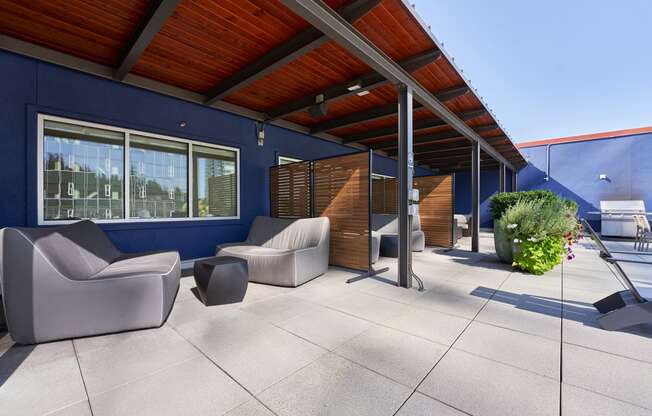 the outdoor patio of the home has couches and chairs and awning