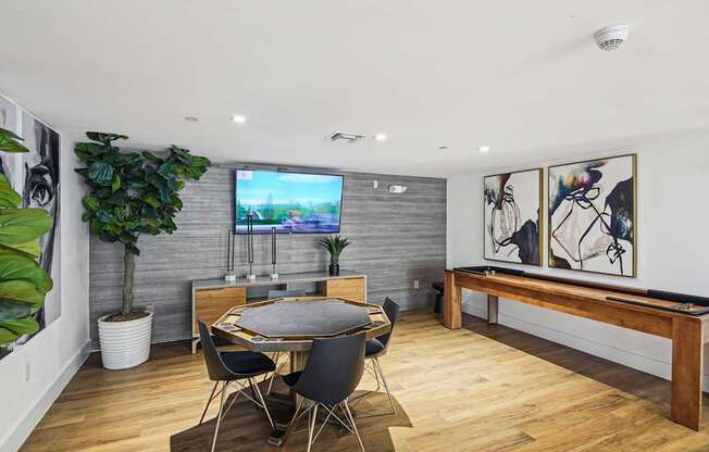 Resident gaming zone with a TV and a potted plant and shuffleboard at Twenty2 West luxury apartments in Miami, FL
