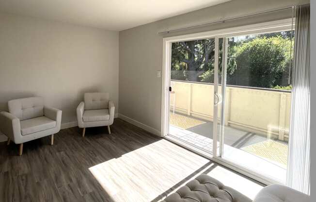 a living room with a couch and chairs and a sliding glass door