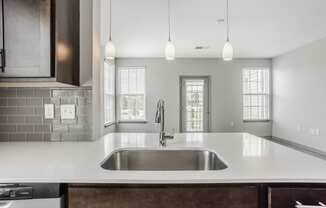 a kitchen with white counter tops and a sink