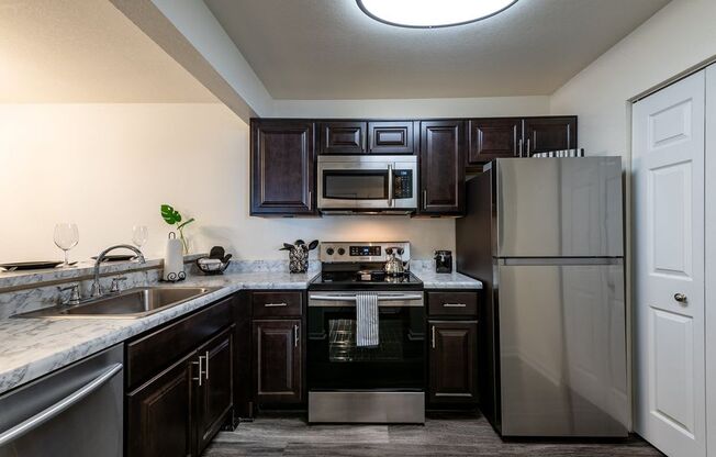 Renovated kitchen with dark cabinetry and stainless steel appliances.