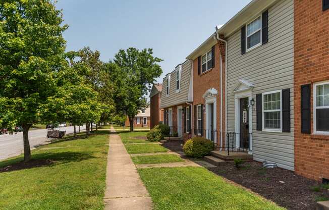 a sidewalk in front of a row of houses