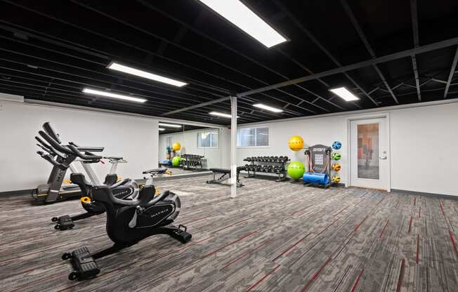 a workout room with exercise equipment and weights in a building with white walls and carpet at Talavera in Boise, ID