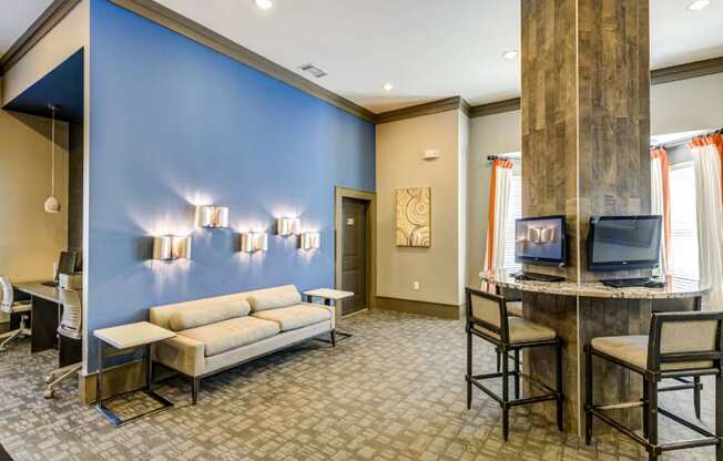 A blue wall with lights and a couch in front of it.