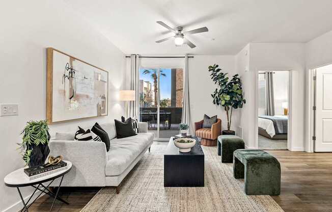 A living room with a grey couch, a coffee table, and a large painting on the wall.