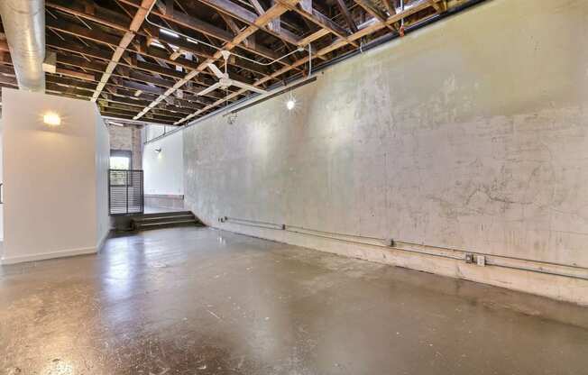 a large empty room with a concrete floor and a white wall