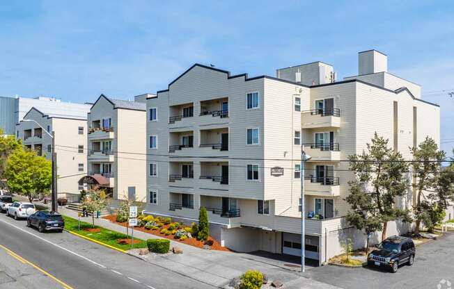 A modern apartment building with cars parked in front.