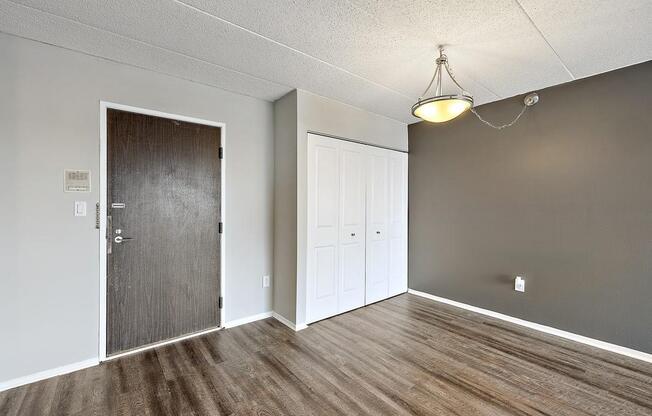 Unfurnished living room with a door to a closet at Troy Place Apartments - Troy, MI, Troy, Michigan