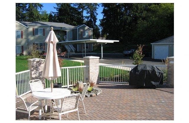 a patio with a table and chairs and an umbrella