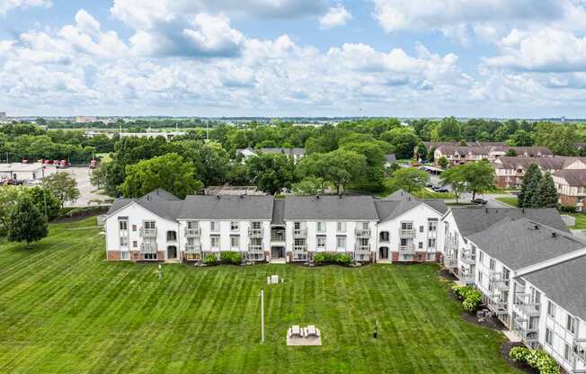 A large white building with a green lawn in front