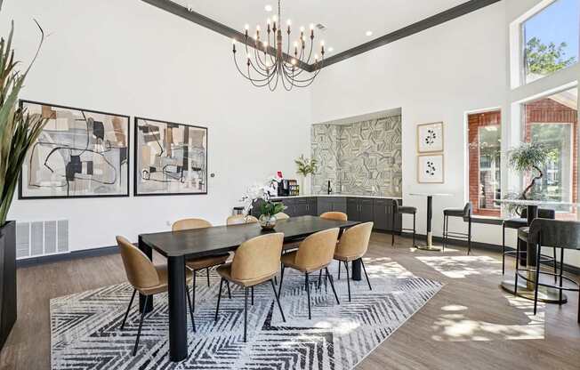 A dining room with a black table and chairs.