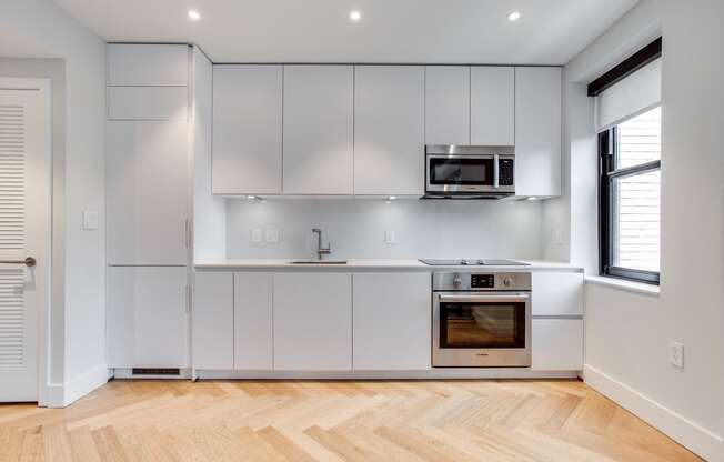 Century studio kitchen with dishwasher, integrated fridge and granite counters