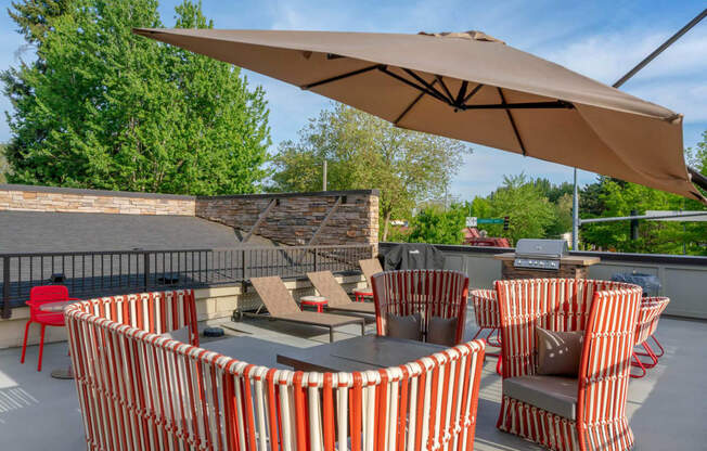 a patio with tables and chairs and an umbrella  at Delano, Redmond, WA 98052