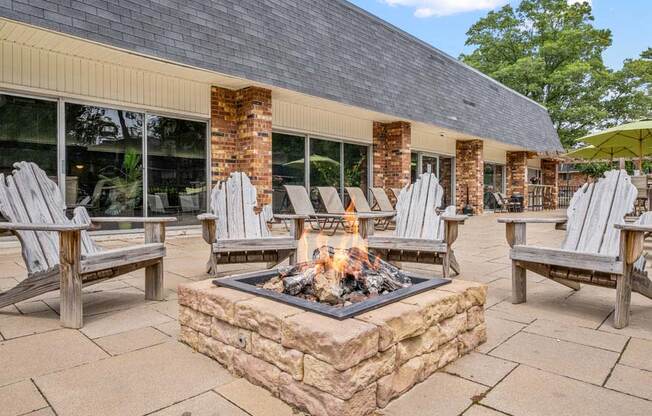 a patio with a firepit and chairs outside of a building
