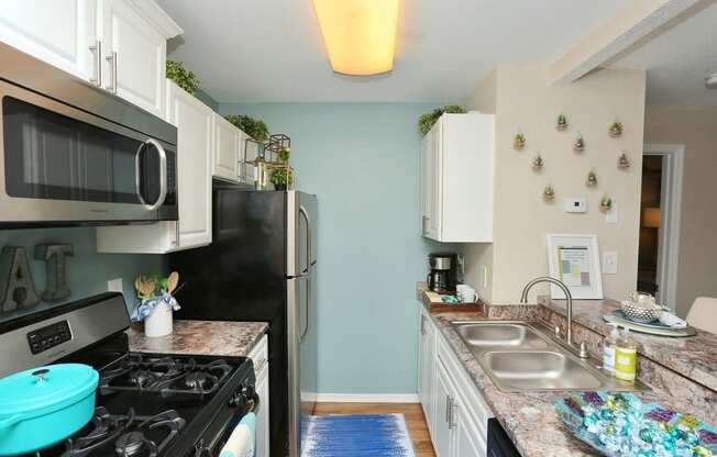 a kitchen with a stove and a refrigerator and a sink