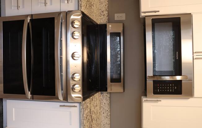 a kitchen with three microwave ovens on the wall