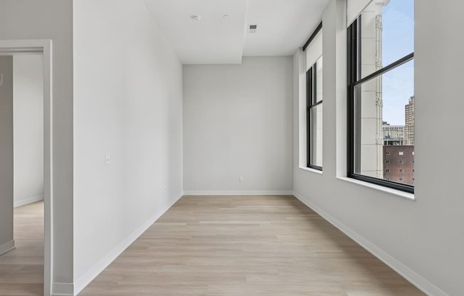 Empty room with white walls and wooden floor.