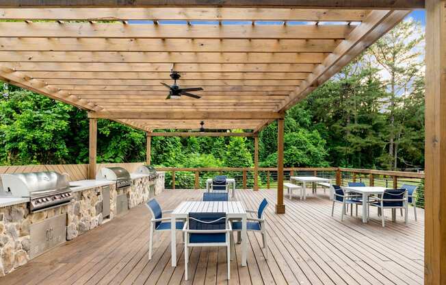 A wooden deck with a table and chairs and a ceiling fan. at Mill House at East Cobb, Marietta Georgia
