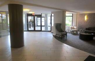 A large room with a pillar, chairs, and a table.