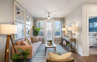 A well-lit living room with a sofa, a chair, and a potted plant.