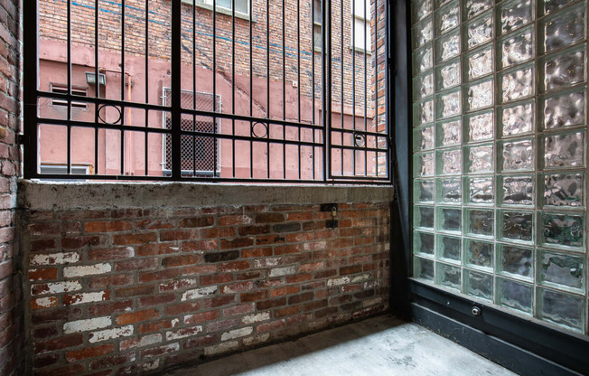 the side of a brick building with a balcony and a brick wall