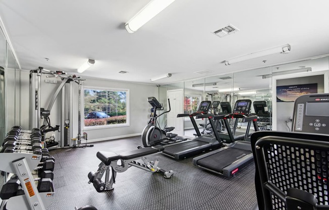 Fitness center equipped with cardio equipment and weights at Oakley Run apartments in Smyrna, GA