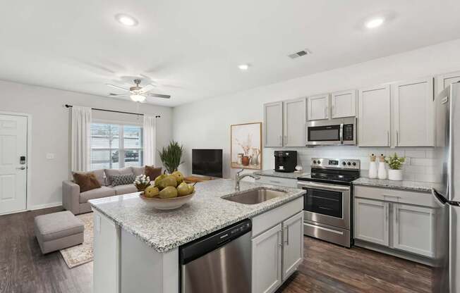 A modern kitchen with stainless steel appliances and a marble island.