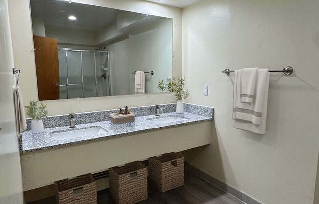 A bathroom with a vanity, mirror, and baskets.