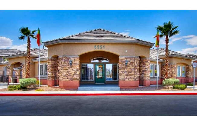 The image shows a building with the number 6551 on it, surrounded by palm trees and a clear sky.