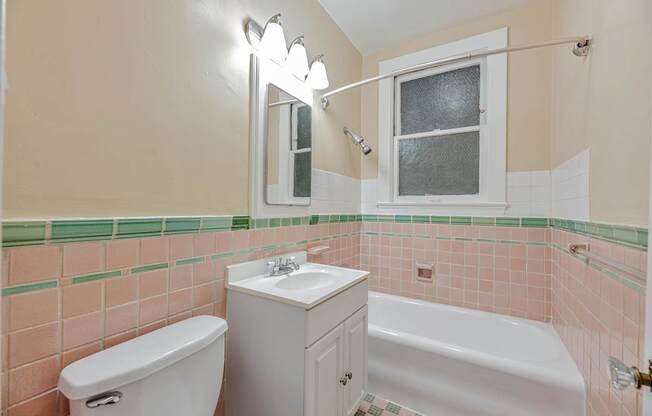 A white toilet sits next to a white sink in a bathroom.