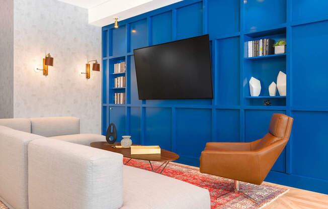A living room with a white couch, a brown chair, and a blue wall.