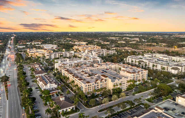 A cityscape with buildings and roads under a sunset sky.
