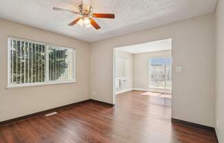 A room with a ceiling fan and wooden flooring.