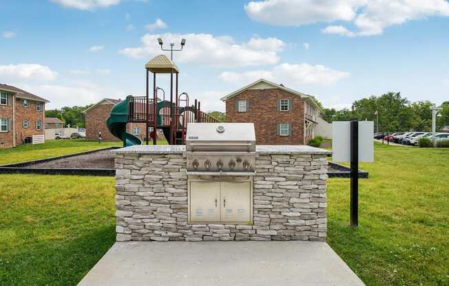 A playground with a slide and a stone structure in the foreground.