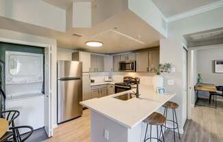 A modern kitchen with a white island and stainless steel appliances.