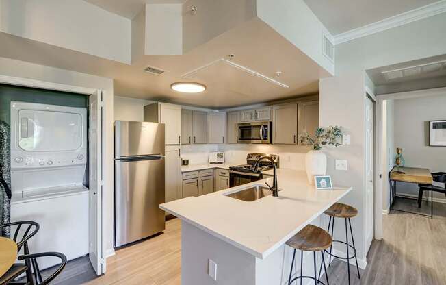 A modern kitchen with a white island and stainless steel appliances.