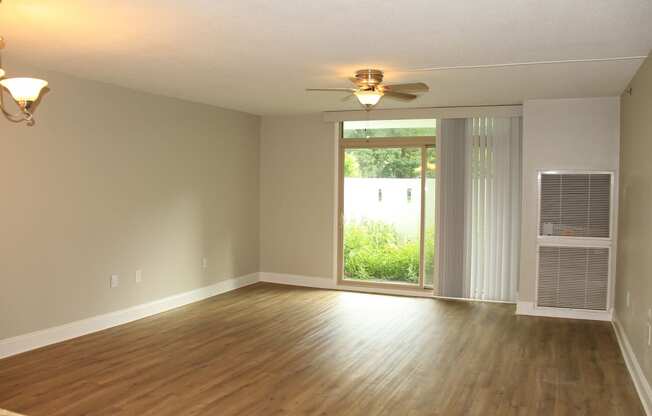 an empty living room with a ceiling fan and a windowat Renew Worcester, Massachusetts, 01602