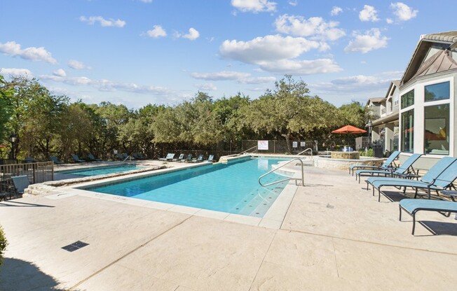 a swimming pool in a resort with chairs and a blue sky stock images