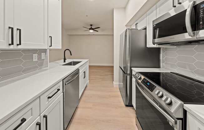 a kitchen with white cabinets and stainless steel appliances