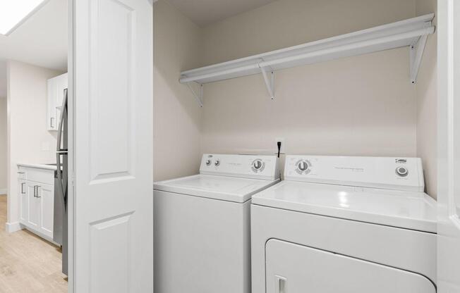 A white laundry room with a washer and dryer.