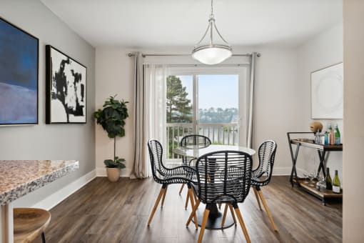 a dining area with a table and chairs and a large window with a view of the water at Linkhorn Bay Apartments, Virginia Beach