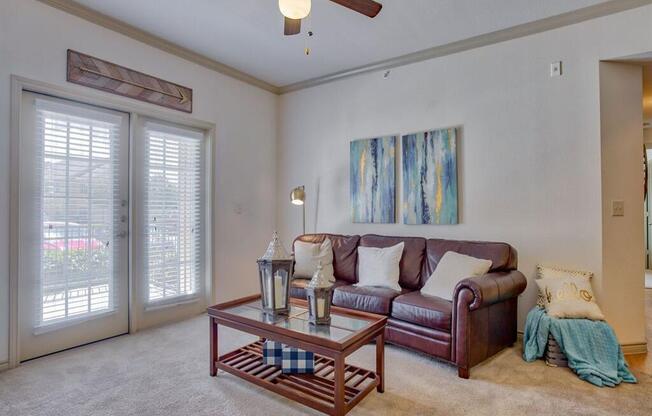 Living room with carpet, ceiling fan, and glass doors