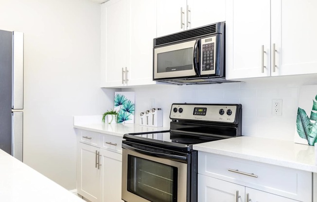 A black microwave oven is on top of a stove.