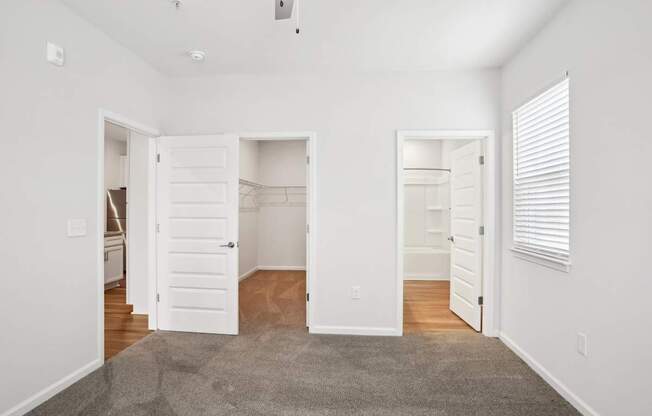 A room with white walls and a grey carpet.