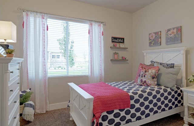 Second bedroom with twin bed, nightstand, dresser, and large window